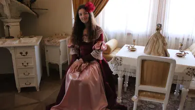 Princezna sedí u stolu s čajovou panenkou