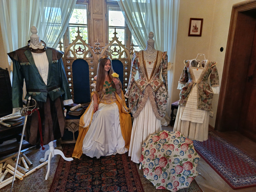 Princezna sedí na trůnu a prohlíží si žlutou růži