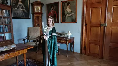 Princezna v gotických šatech s bílou květinou.